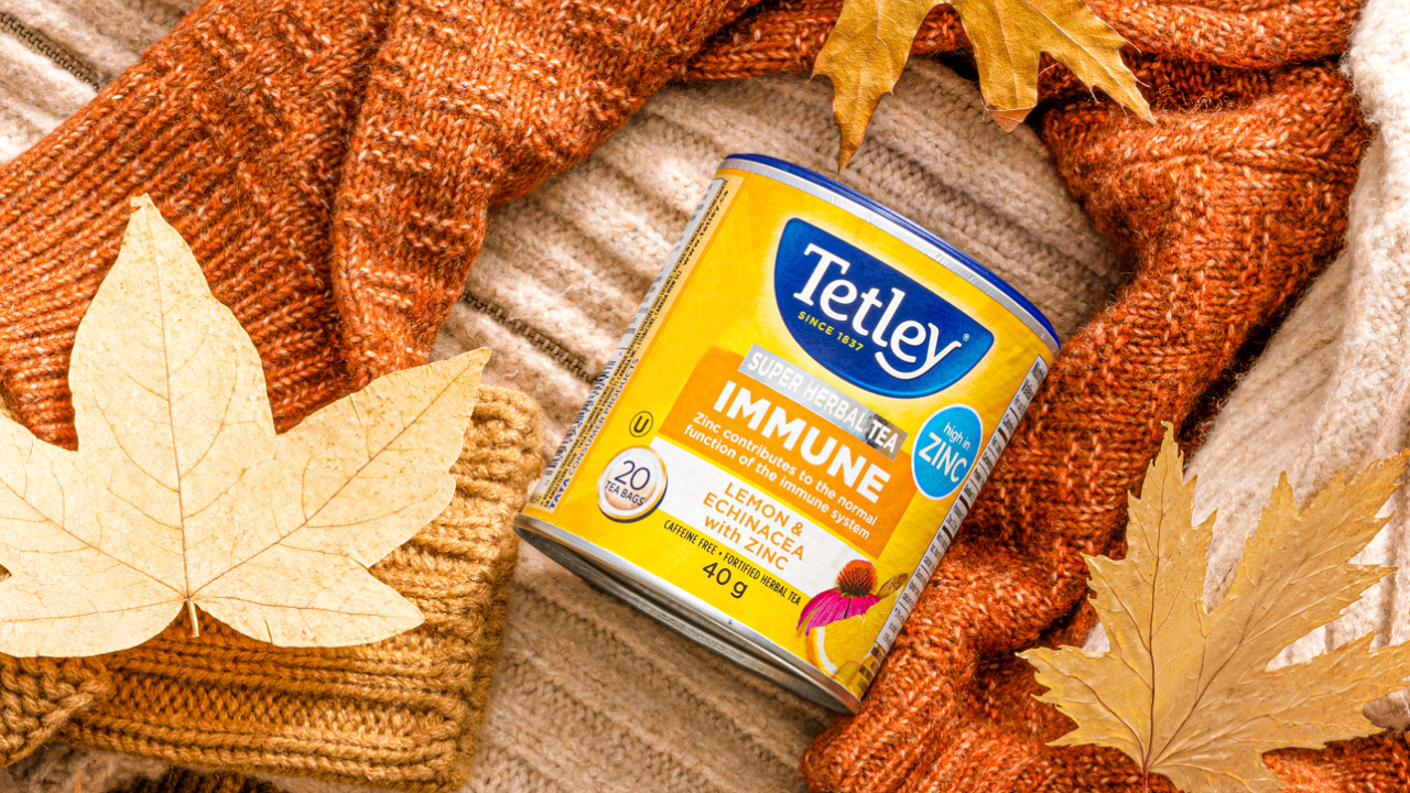 A canister of Tetley Super Immune tea placed atop cozy knit sweaters.